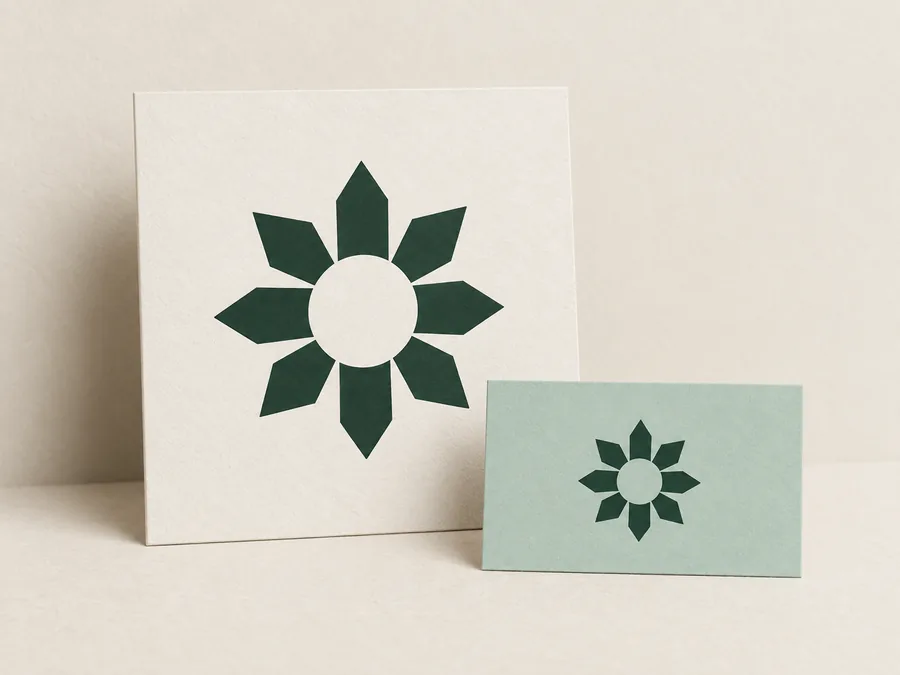 Dunkelgrünes geometrisches Sonnenzeichen auf elfenbeinfarbenen und mintgrünen Karten. Illustratives Marken-Mockup.